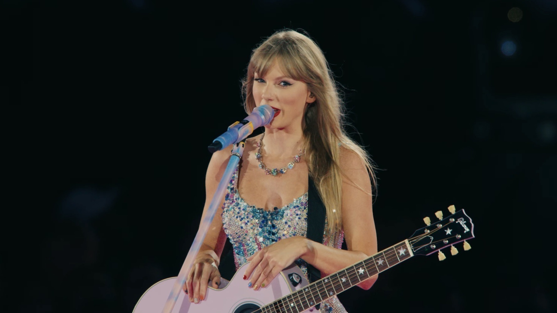 Taylor Swift playing a guitar at the Taylor Swift: The Eras Tour