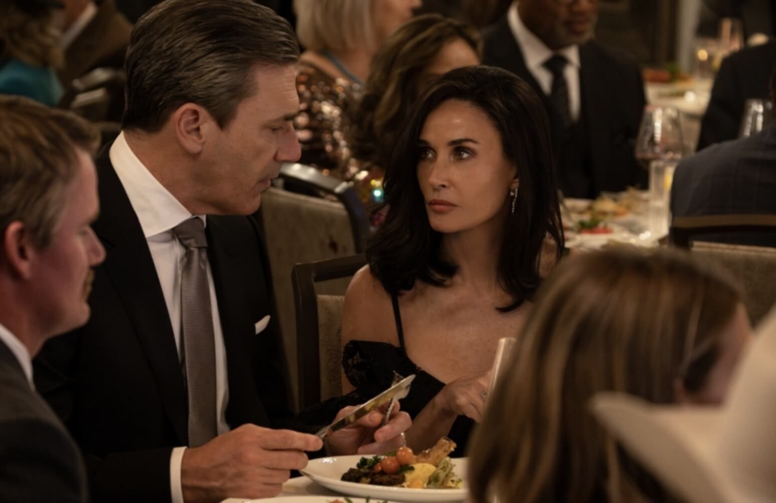 Demi Moore and Jon Hamm sitting at a table, in Landman Paramount+ series
