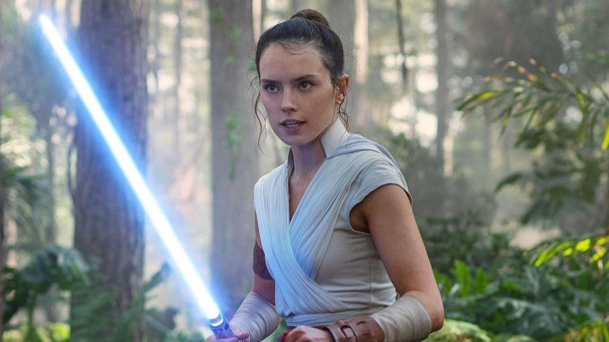 Daisy Ridley as Rey Skywalker, weilding a lightsaber in a forest