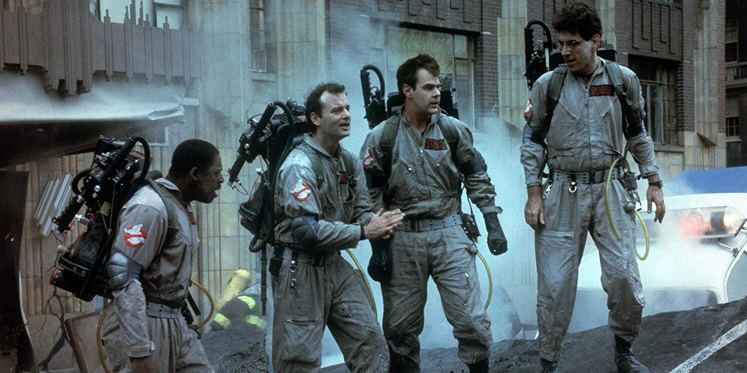 Winston, Peter, Ray and Egon wearing the Ghostbusters outfits in the comedy horror movie with proton packs 