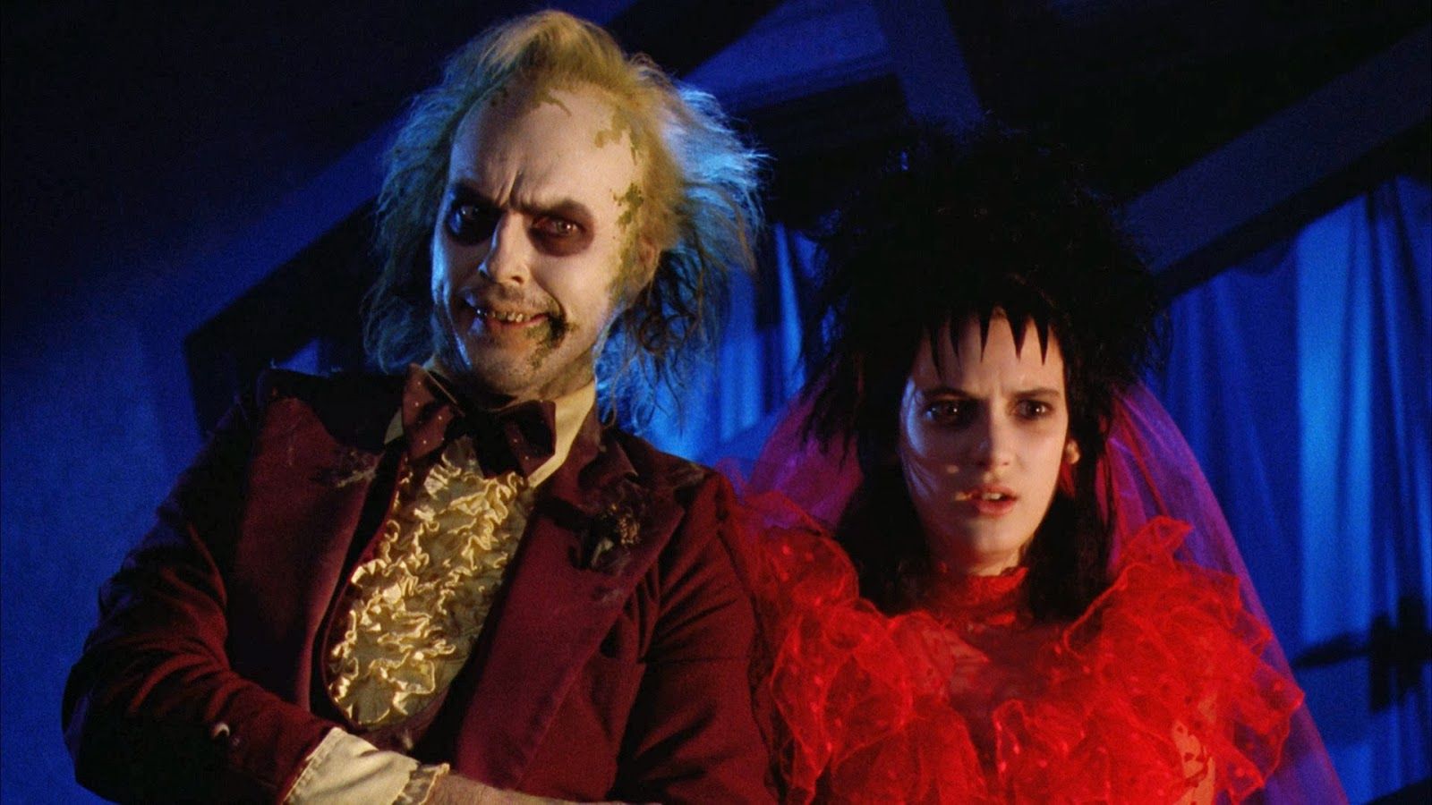 Michael Keaton as Betelgeuse and Winona Ryder as Lydia Deetze dressed in goth wedding outfits