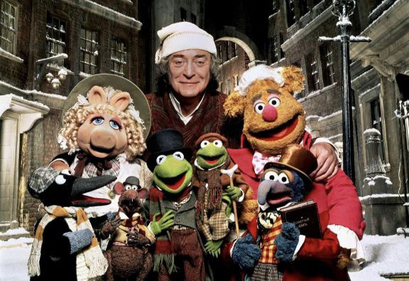 Michael Caine as Ebenezer Scrooge in a group photo with the muppets