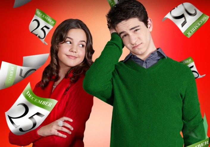 Bailee Madison and Zachary Gordon posing infront of a red background with calendar pages floating: December 25