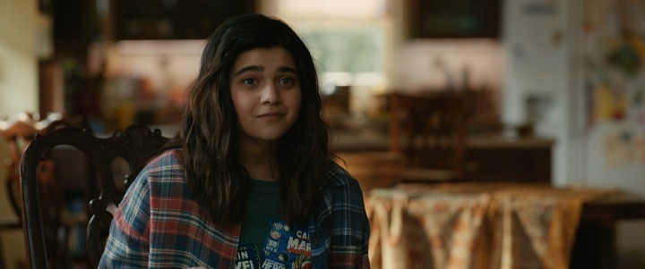 Iman Vellani as Kamala Khan sitting down at the Khan family home.