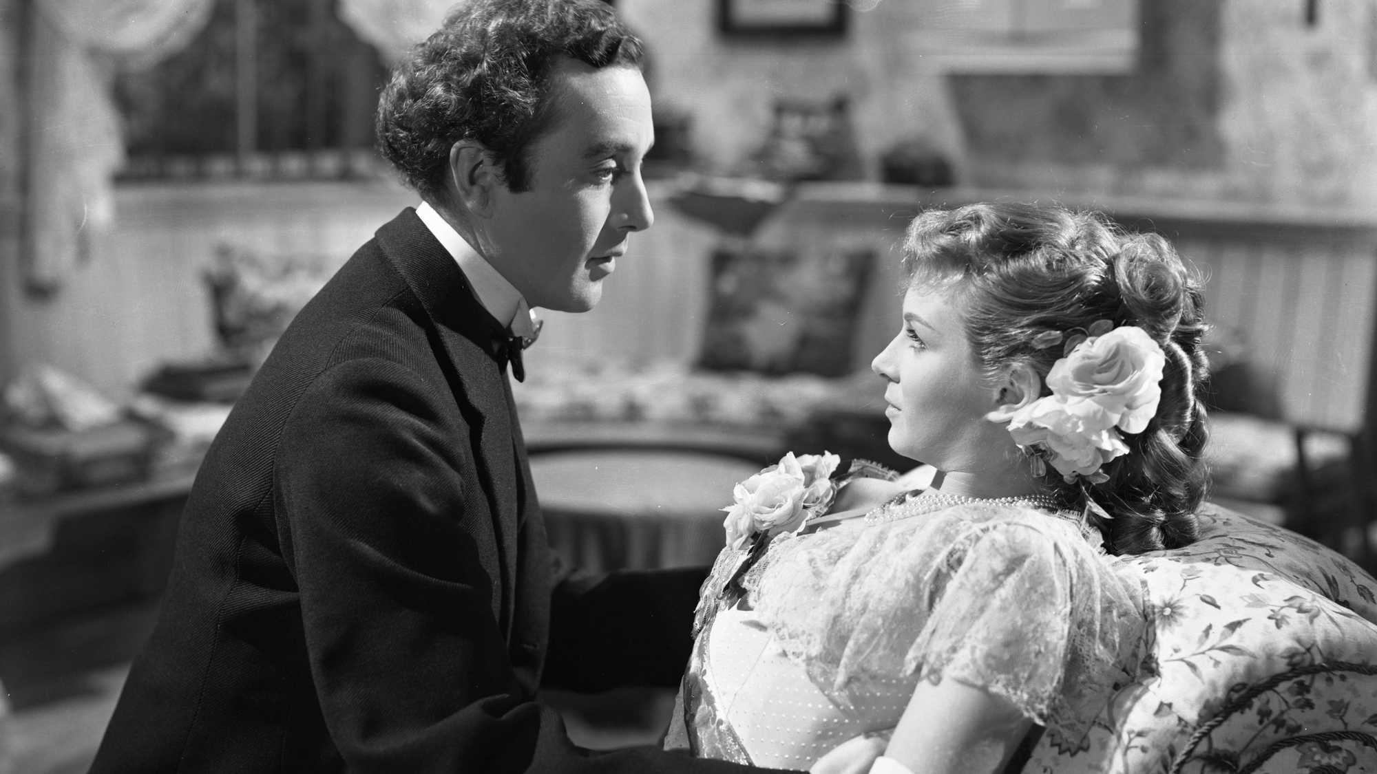 A man looking into a woman's eyes as she leans back, in a scene from Kind Hearts and Coronets