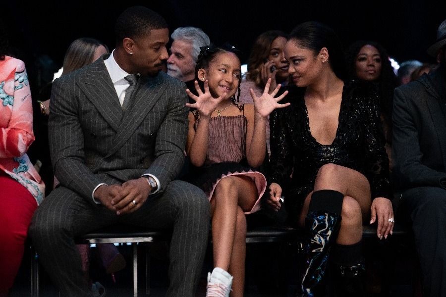 Adonis Creed, Amara and Bianca sitting in an audience at a boxing match