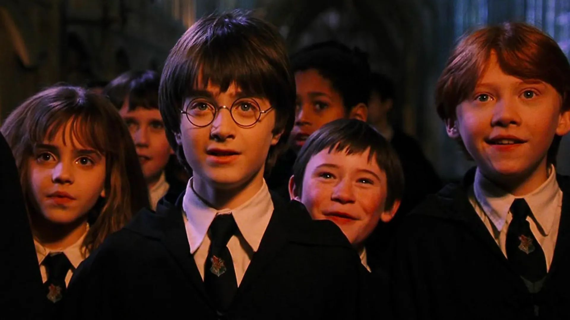 Hermione, Neville, Harry, Seamus, and Ron react surprised, while in their Hogwarts uniform