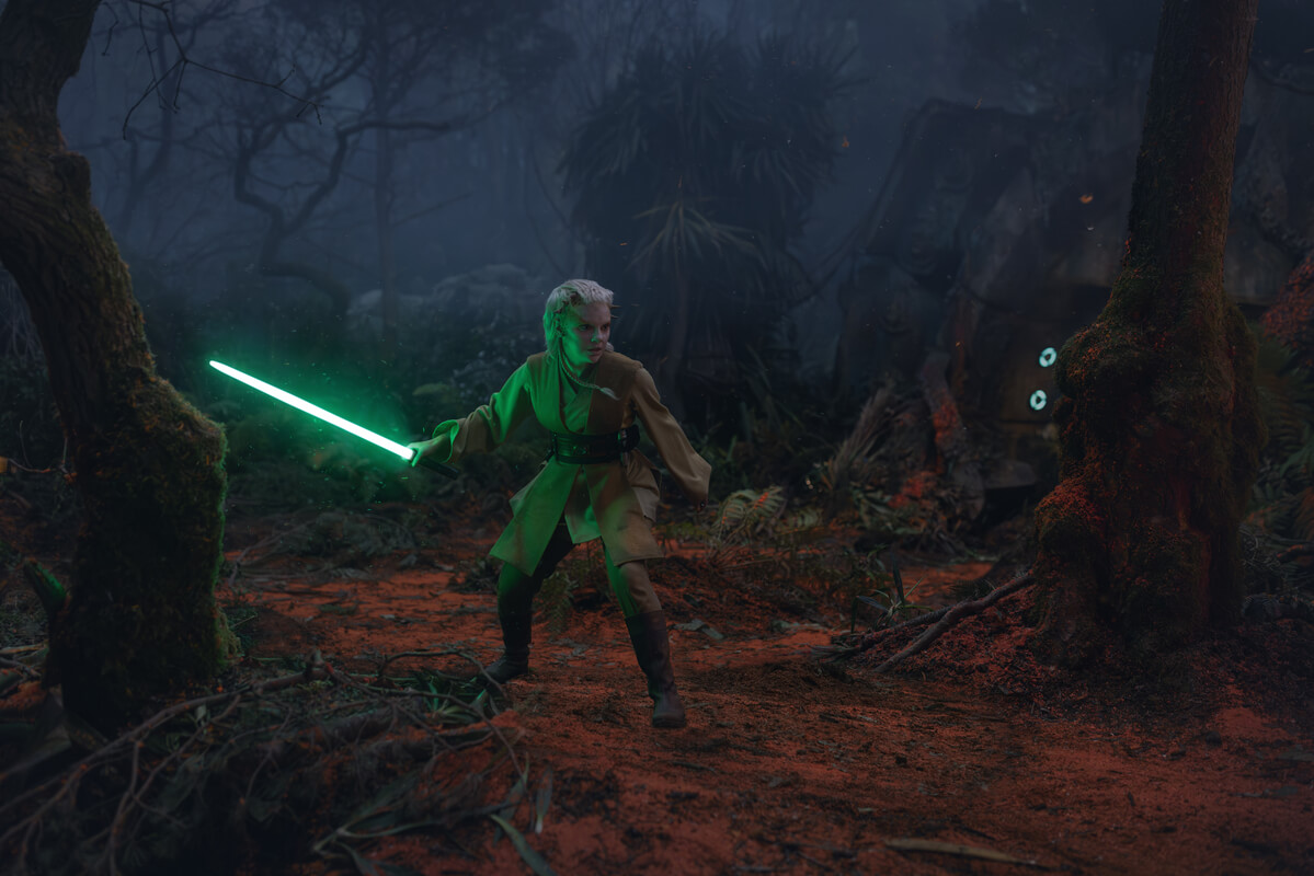 Jecki Lon is using a lightsaber in a forest to defend herself from a threat in Star Wars The Acolyte episode 5