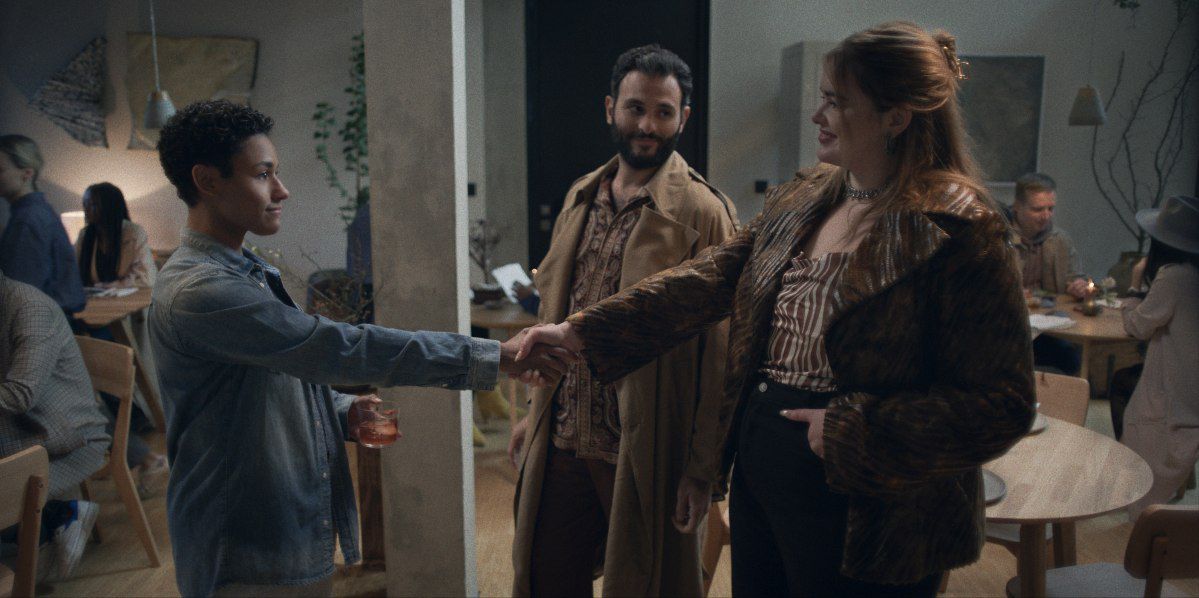 Ariana DeBose is meeting two people, shaking on their hands in House of Spoils.