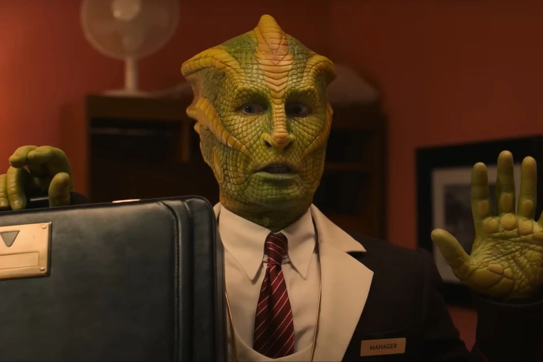 Silurian in a suit putting his hands up, while holding a brief case at the hotel Doctor Who