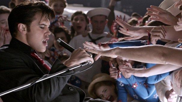 Austin Butler as Elvis Presley, performing on stage infront of a crowd