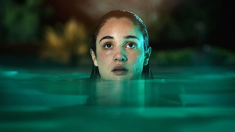 A woman with her head just above the water looking at something off-screen, in Bad Influence film