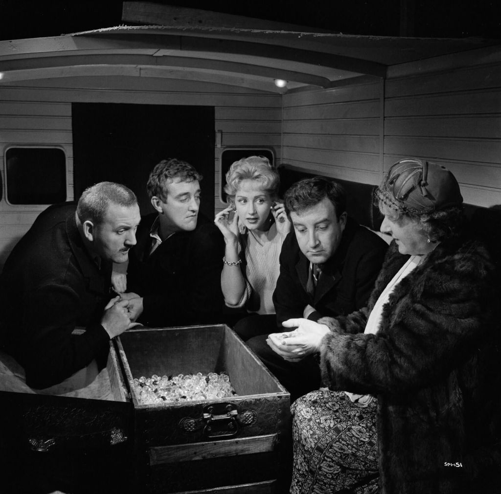 A black and white group scene in Two Way Stretch, characters are looking at a box of diamonds.