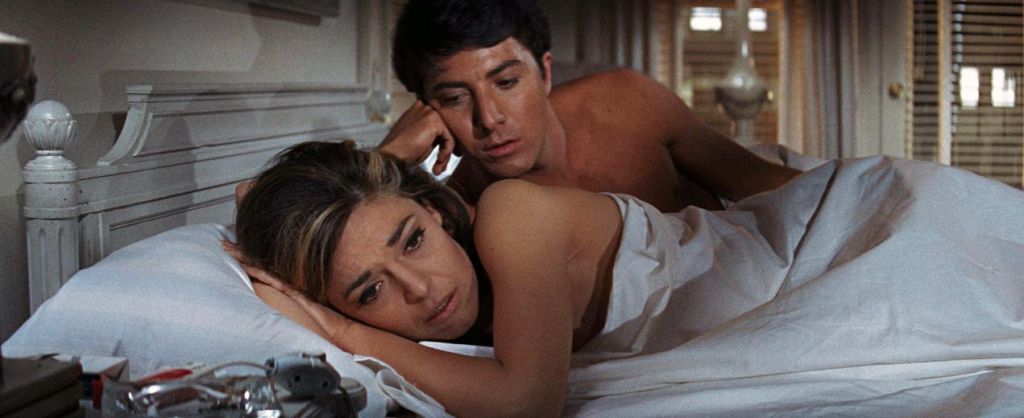 Dustin Hoffman and Anna Bancroft laying in bed, in the Graduate