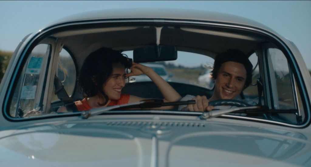 Paulette sitting in a car with Paul as they both smile