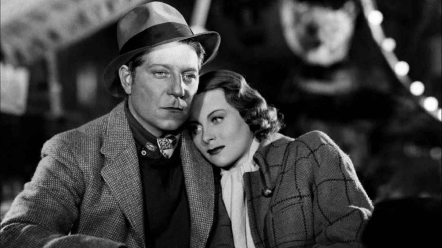 Two characters in black and white embracing eachother in Le Quai Des Brumes