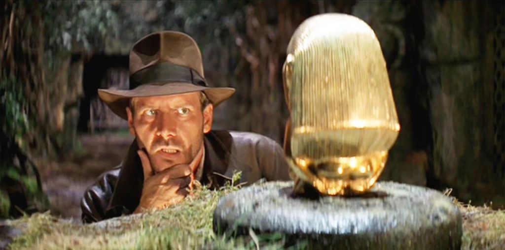 Harrison Ford as Indiana Jones, looking at a golden artefact.