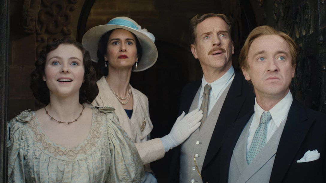 Thomasin Mackenzie, Katherine Waterston, Damian Lewis and Tom Felton looking surprised by something off screen, dressed in old fashion attire