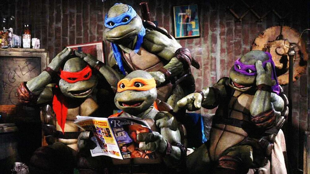 All four teenage ninja turtles gathered round looking at a magazine