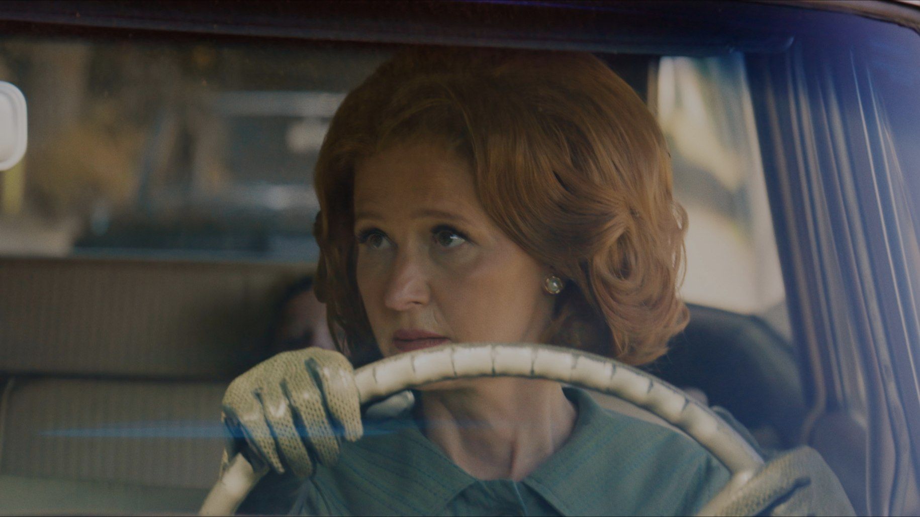 A woman is sitting behind the steering wheel of 1962 Colony Park Station Wagon.